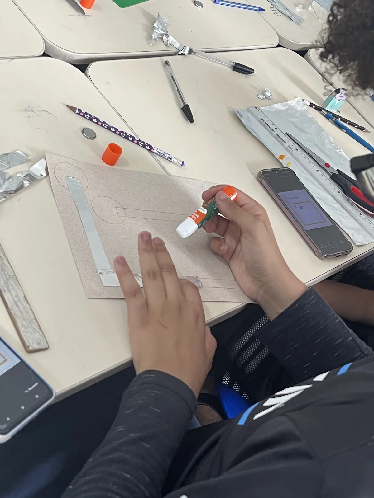Estudante monta um circuito simples com fita de cobre e LED
